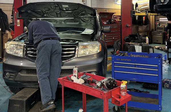 Our Expert Staff Performing Maintenance in Garage | Bauer Automotive Service